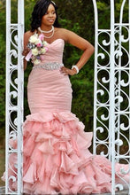 Load image into Gallery viewer, Woman in a pink dress standing in front of a decorative white archway.