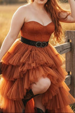 Cargar imagen en el visor de la galería, Woman in an orange dress and cowboy hat standing in a field with pumpkins.