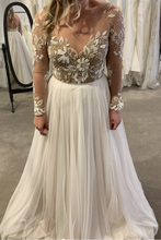Laden Sie das Bild in den Galerie-Viewer, White wedding dress with floral lace top and long sleeves in a fitting room setting.