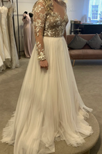 Laden Sie das Bild in den Galerie-Viewer, White wedding dress with floral lace top on a mannequin in a store setting.