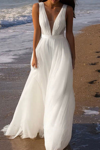 Woman in a white dress standing on a beach
