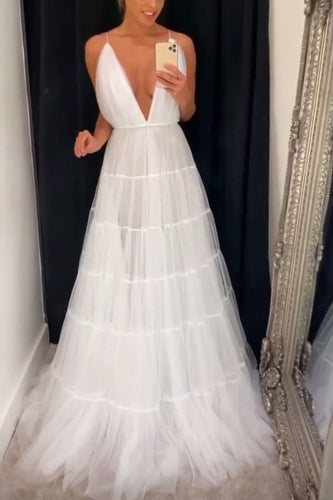 Woman in a white wedding dress standing in front of a mirror.