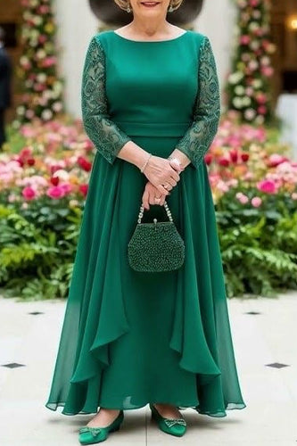 Woman in a green dress holding a matching handbag in an elegant indoor setting with floral decorations.