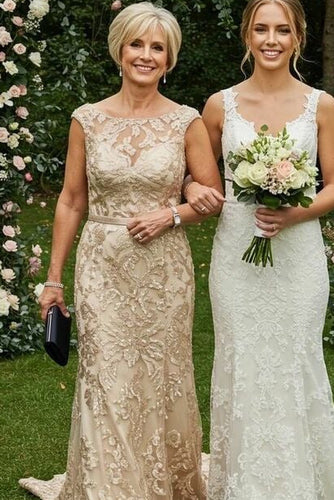 Two women in lace dresses standing in front of a floral archway.