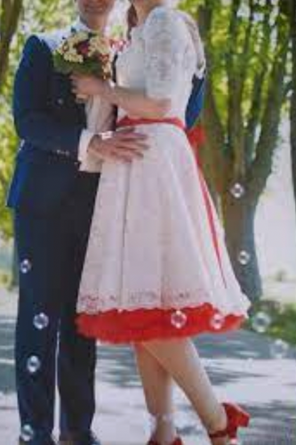 Two people in formal attire standing outdoors with trees in the background
