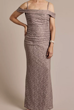 画像をギャラリービューアに読み込む, Woman wearing a long, patterned off-shoulder dress against a neutral background