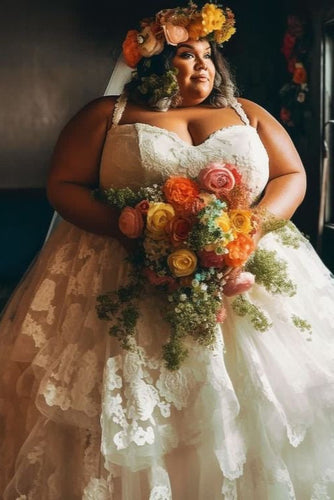 Woman in a wedding dress holding a bouquet of flowers indoors.