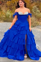 画像をギャラリービューアに読み込む, Woman in a blue off-shoulder gown with ruffled layers standing outdoors.