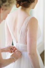 Load image into Gallery viewer, Bride getting ready with a close-up of her dress and hair.