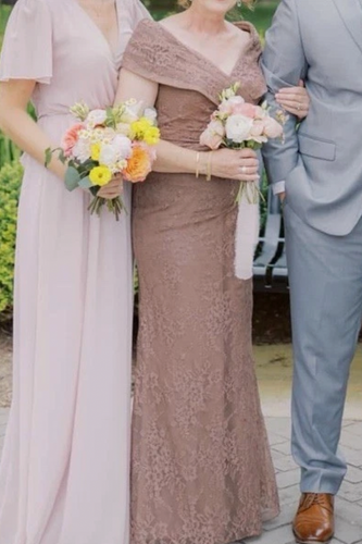 Three people in formal attire standing together outdoors.