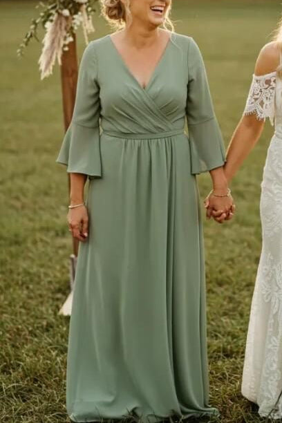 Two women walking hand in hand in a field with floral decorations.